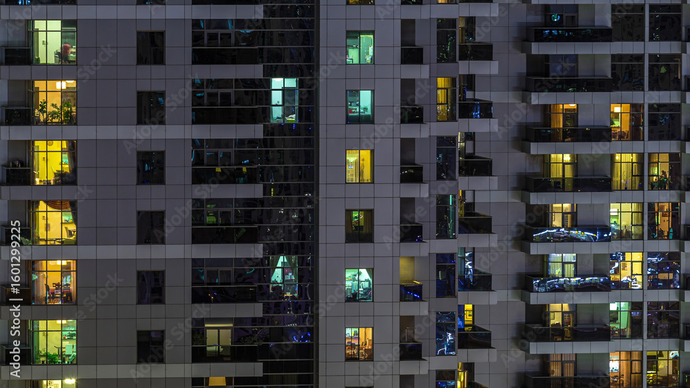 Rows of glowing windows with people in apartment building at night. Rows of glowing windows with people in apartment building at night.