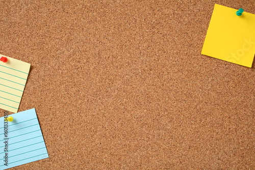 Fotografía Pinned yellow and blue notes on corkboard with vibrant pushpins