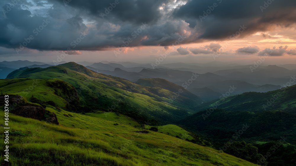 Obraz premium Rolling green hills landscape at sunset with scenic view of valleys and mountains under cloudy skies
