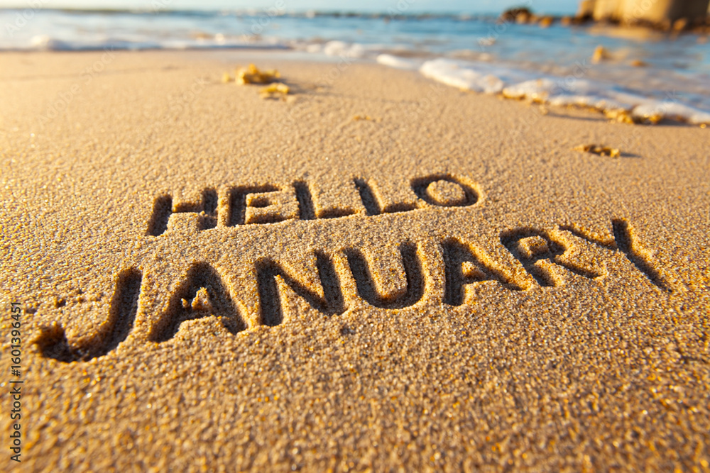 Fototapeta premium New Year Phrase HELLO JANUARY Written in Wet Beach Sand with Clean Bold Letters and Soft Texture for Calendar or Promo Use