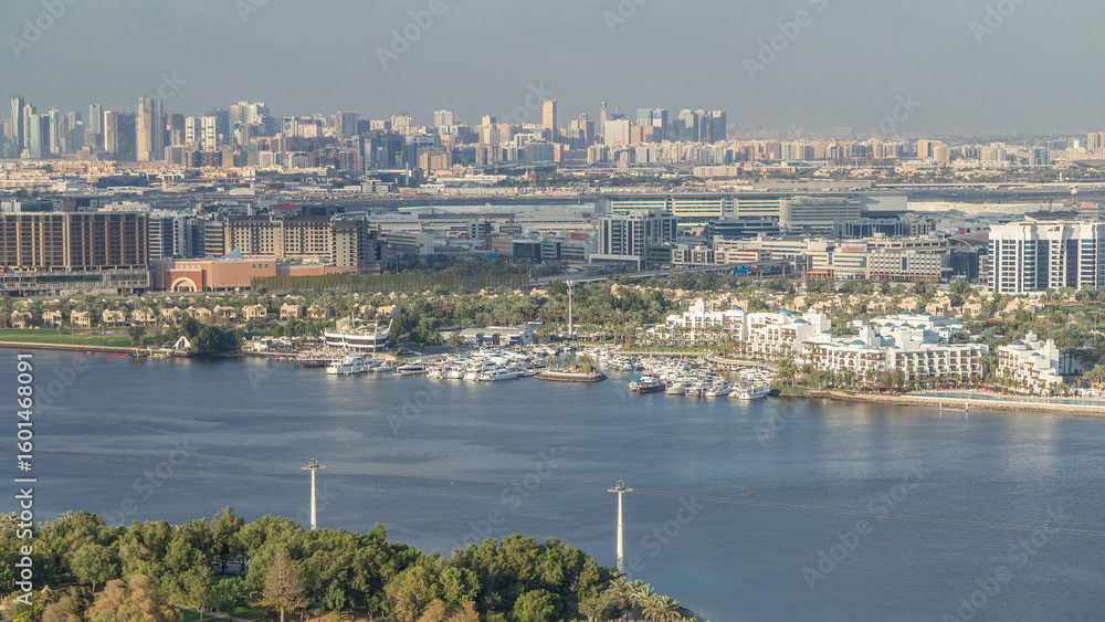 Fototapeta premium Aerial view of blue canal near green park Dubai city, United Arab Emirates Timelapse