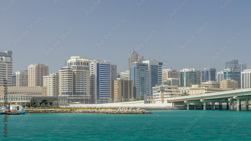 Fototapeta premium Modern buildings in Abu Dhabi skyline timelapse with mall and beach.