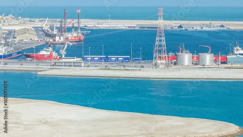 Big cargo ship at industrial port timelapse aerial view from above at evening in Abu Dhabi
