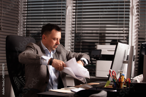 Φωτογραφία Frustrated businessman throws documents in the air, expressing stress and burnout