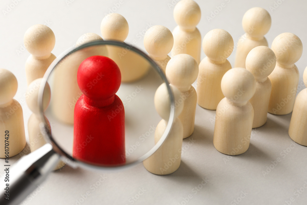 Obraz premium Unemployment. Human figures and magnifying glass on light background, closeup