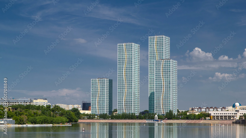Fototapeta premium Yesil river timelapse with modern towers of residential complex in Astana