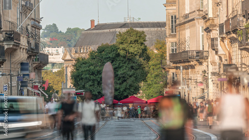 Fototapeta Naklejka Na Ścianę i Meble -  L'Intendance Street in Bordeaux timelapse during sunset with modern trams