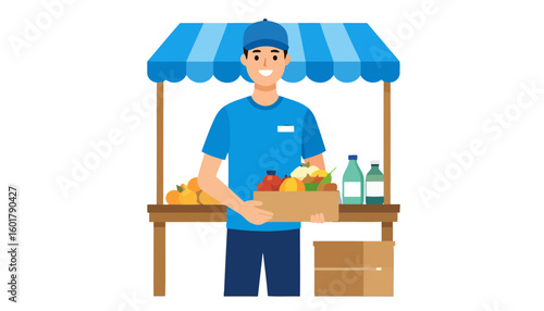 Friendly young vendor in a blue uniform holding a cardboard box of fresh produce at a market stall.