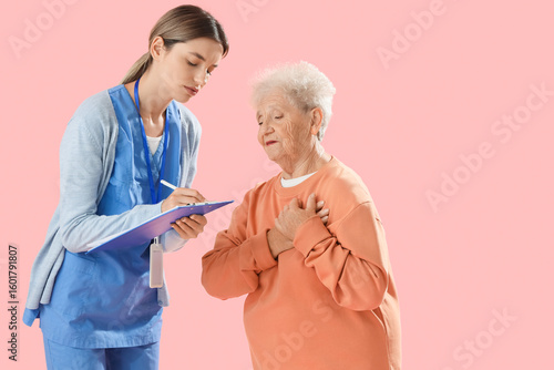 Ill senior woman with nurse...