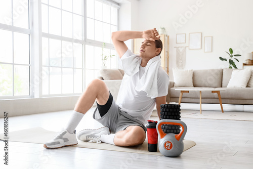Tired sporty young man with...
