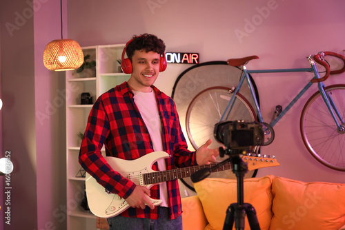 Male blogger with guitar re...