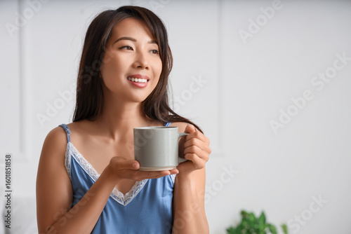 Young Asian woman with cup ...