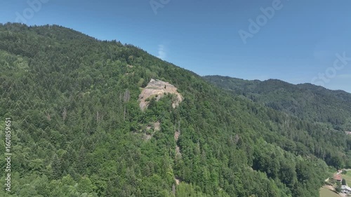 Aerial view of partially restored medieval Rocafort castle in Savoy France on a hilltop with blue sky