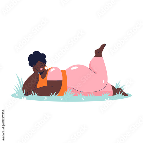 Plus size black woman relaxing in grass with a peaceful expression  