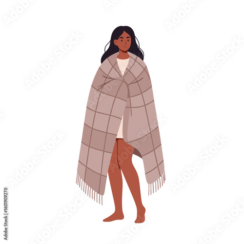 Young woman wrapped in a blanket standing indoors  