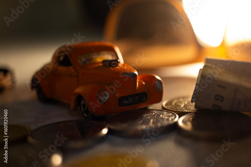 macro shot of a toy car along with coins and yellow light