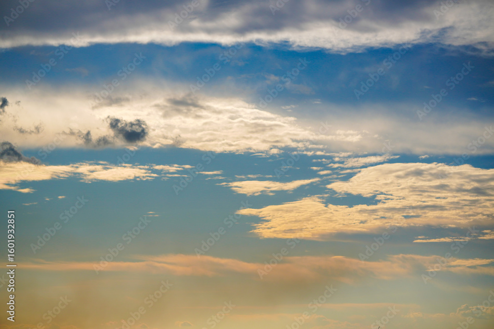 Obraz premium Beautiful evening sky with colorful orange and blue clouds reflecting on the water at dusk. Serene and peaceful nature background.