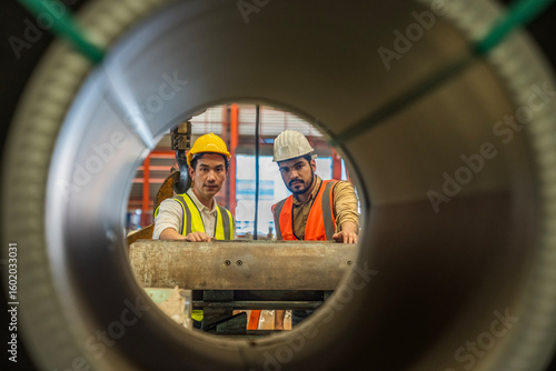 Engineers actively monitor the production line in a metal sheet factory. Engineer working hard in Metal Sheet factory.