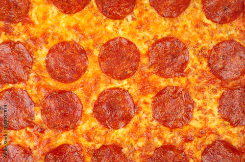 Fotografija Baked spicy pepperoni and cheese pizza background texture detail