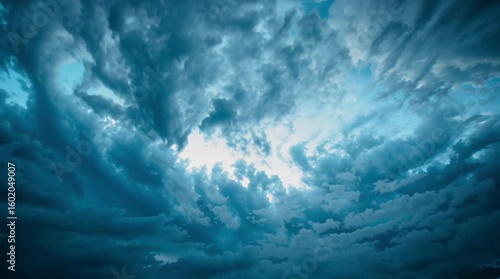 Clouds move quickly across a deep blue sky in a dramatic time-lapse moment. Light and shadow shift as weather patterns change, capturing nature's movement and ever-changing atmosphere.