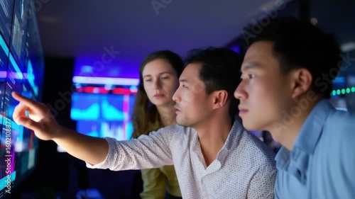 Team in Data Analysis: Three individuals collaboratively analyzing data, pointing at the screen, highlighting the essence of teamwork and deep analysis