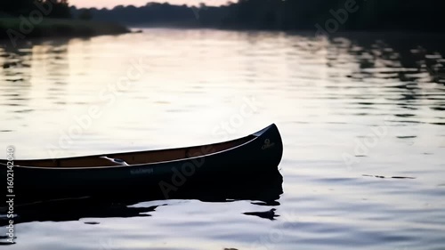 Still canoe on calm water at dusk