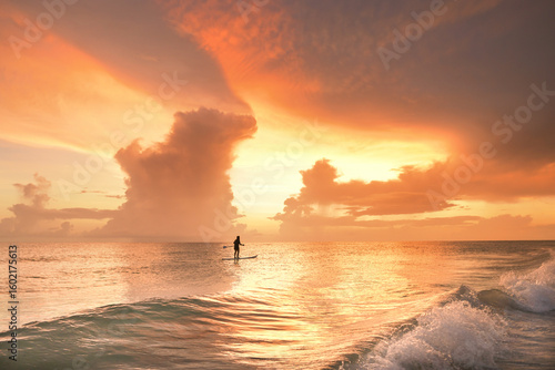 Profile teenage girl paddle board golden sunset Gulf of Mexico