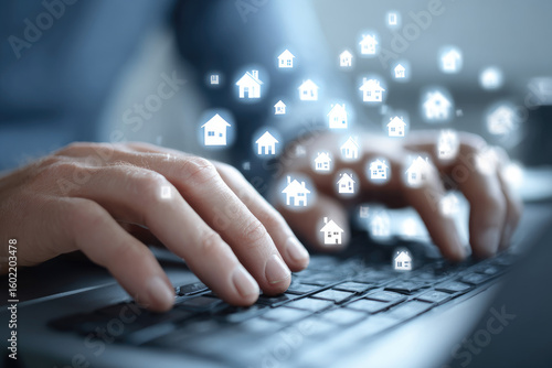 Close-up of hands typing on laptop keyboard, house icons floating above