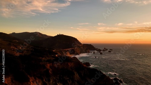 Aerial view of the Bixby Creek Bridge along the rugged coastline where the ocean meets the hills, creating a scenic landscape, Big Sur, California, United States.