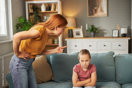 Foto A parent is reprimanding a child seated on a couch