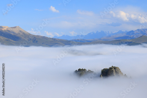 Rocks in the fog of the Elbrus region on a sunny summer day.