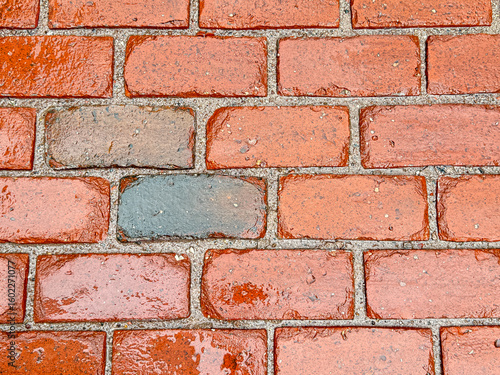 Close-up of wet red brick wall with rain droplets