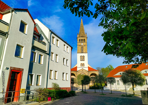 Historic St. Nicholas Church (St.-Nicolai-Kirche) and buildings on Boetzower Platz in Oranienburg, Germany, captured on a spring sunny day. Built in 1866. One of the landmark of Oranienburg’s old town