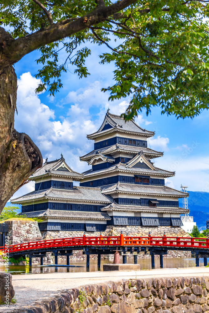 Obraz premium Matsumoto Castle or Crow Castle and the red bridge in summer is one of Japanese premier historic castles in Honshu. Landmark and popular for tourists attraction in Matsumoto city, Japan