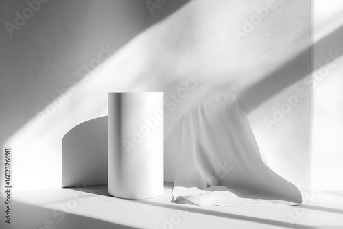 Minimalist scene with cylindrical pedestal and draped fabric in dramatic light