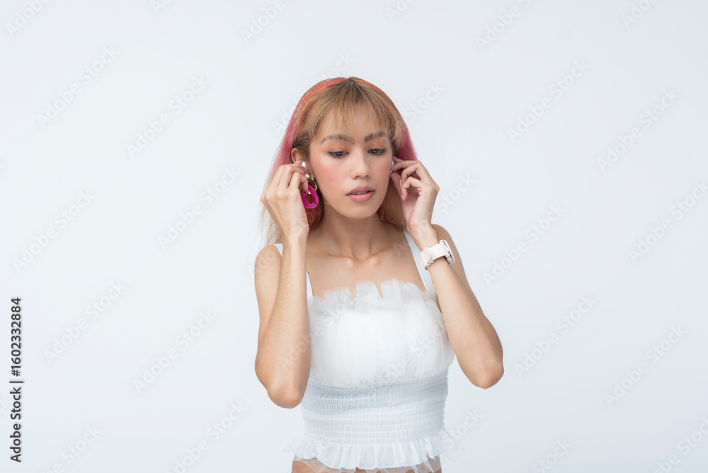 Young Asian woman adjusting or changing earrings Young Asian woman adjusting or changing earrings