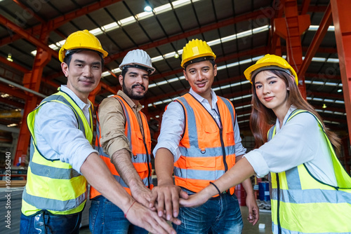 Engineers team in protective helmets and vests standing Metal Sheet machines in factory.  Industrial successful and teamwork concept