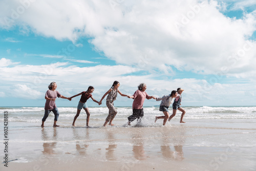 Tablou pe pânză Asian family running happily the beach, healthy retirement lifestyle, strong family relationships, joyful aging, and the importance of planning with insurance and care