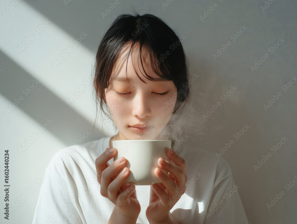 温かい飲み物の香りを楽しむ日本人女性 温かい飲み物の香りを楽しむ日本人女性