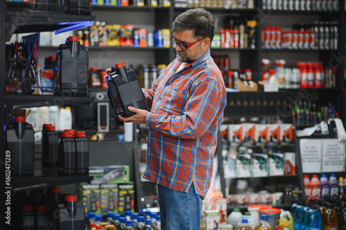 Obraz na plátně Customer choosing motor oil in auto parts store
