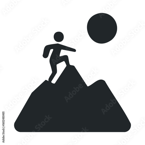 Silhouette of person climbing steep mountain with large backpack