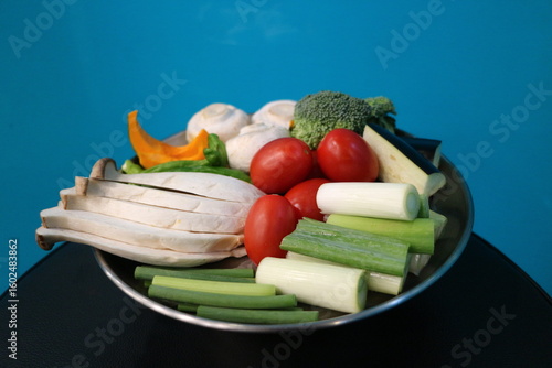 Korean Barbecue Grill Setup with Fresh Beef, Side Dishes, and Vegetables at Traditional Restaurant Table