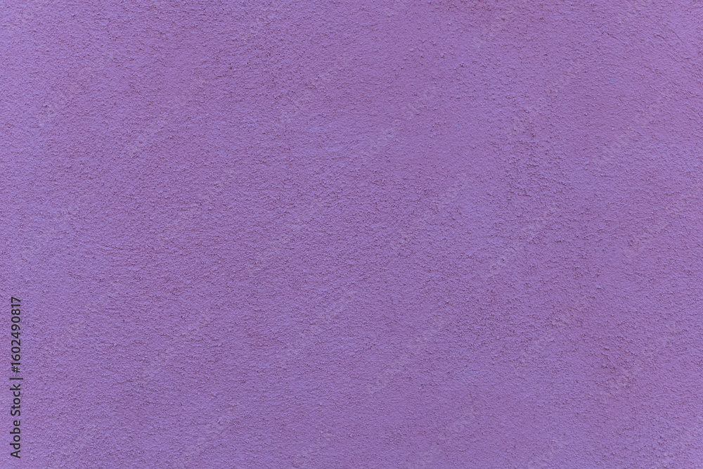 Fototapeta premium Vibrant purple wall texture in sunlight brings life to any setting