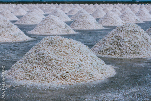 Pyramids of sea salt ready to be harvested in a salt farm at sunrise. Used as a seasoning in food, cosmetics and for food preservation.