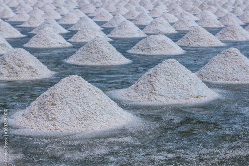 Pyramids of sea salt ready to be harvested in a salt farm at sunrise. Used as a seasoning in food, cosmetics and for food preservation.