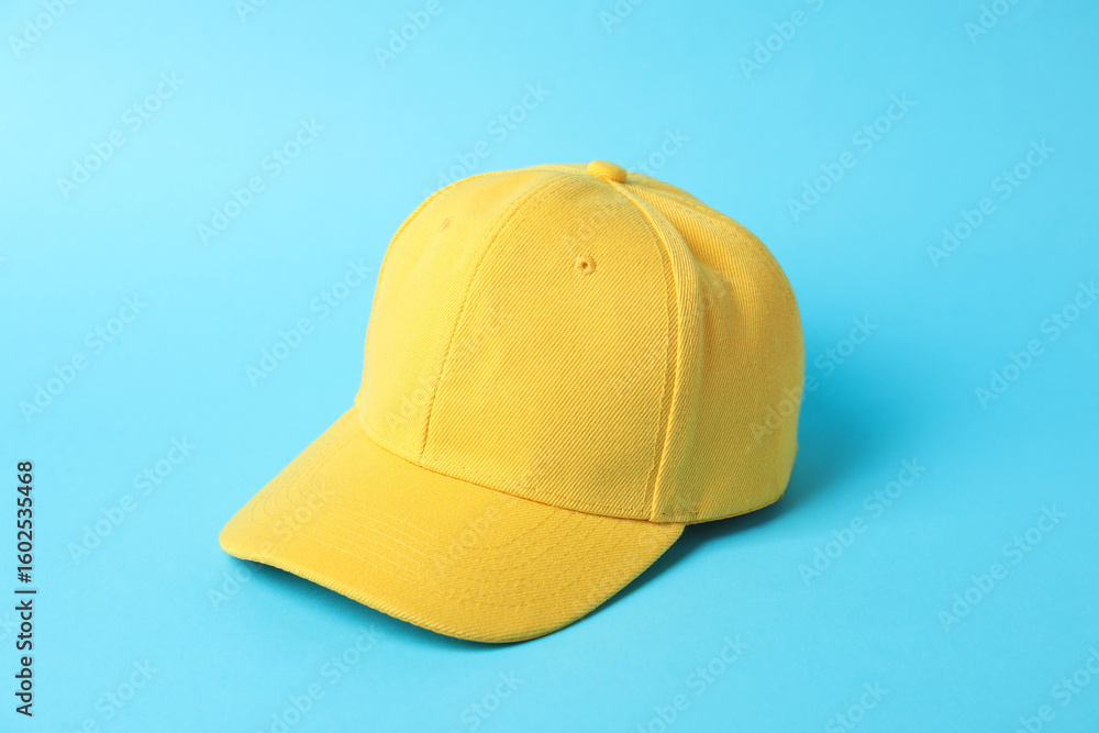 Fototapeta premium Yellow baseball hat on light blue background