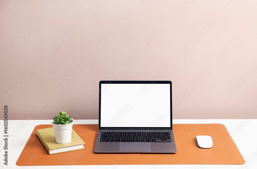 Fototapeta premium Stylish workplace with laptop and orange mousepad on white table indoors. Space for text