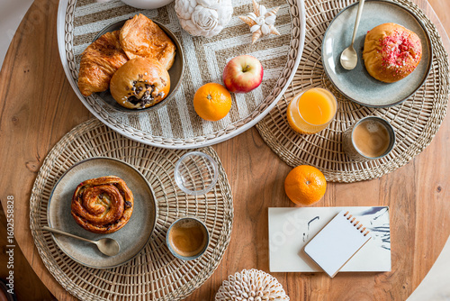 petit déjeuner délicieux vu de dessus composé de café jus d'orange fruits frais oranges pomme croissants et viennoiseries pain au raisin brioche