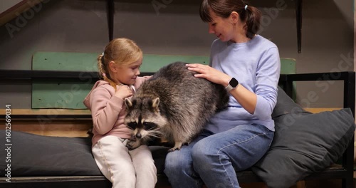 Educational montage showing a girl and a woman petting a raccoon in a contact zoo, fostering connection with wildlife and promoting animal welfare