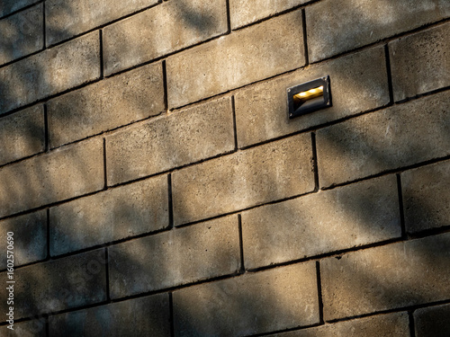 Shadows of trees cast on a large brick wall
